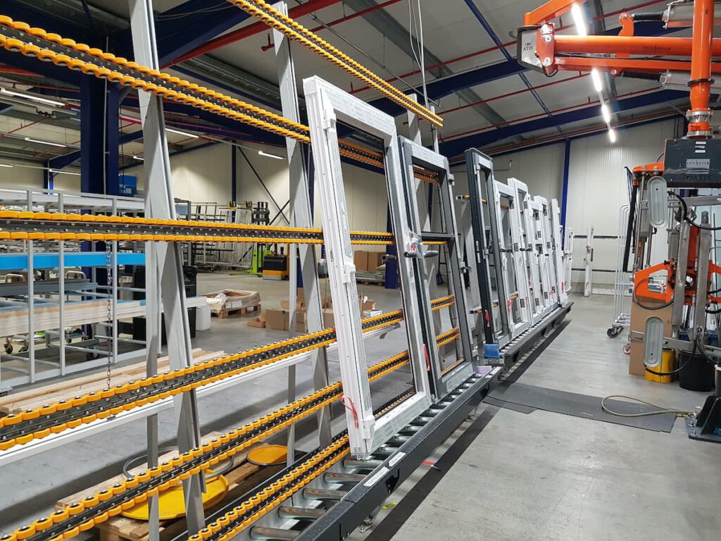 Blick auf eine moderne Produktionslinie in einer Fabrik mit mehreren Fenstern, die auf einem Förderband montiert sind. Die Anlage zeigt eine effiziente Anordnung von Werkzeugen und Materialien, um den Fertigungsprozess zu optimieren.